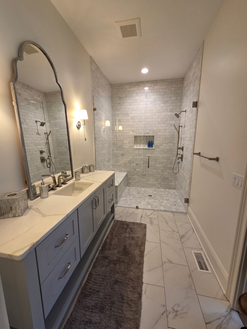 Bathroom with marble subway shower and arched mirror