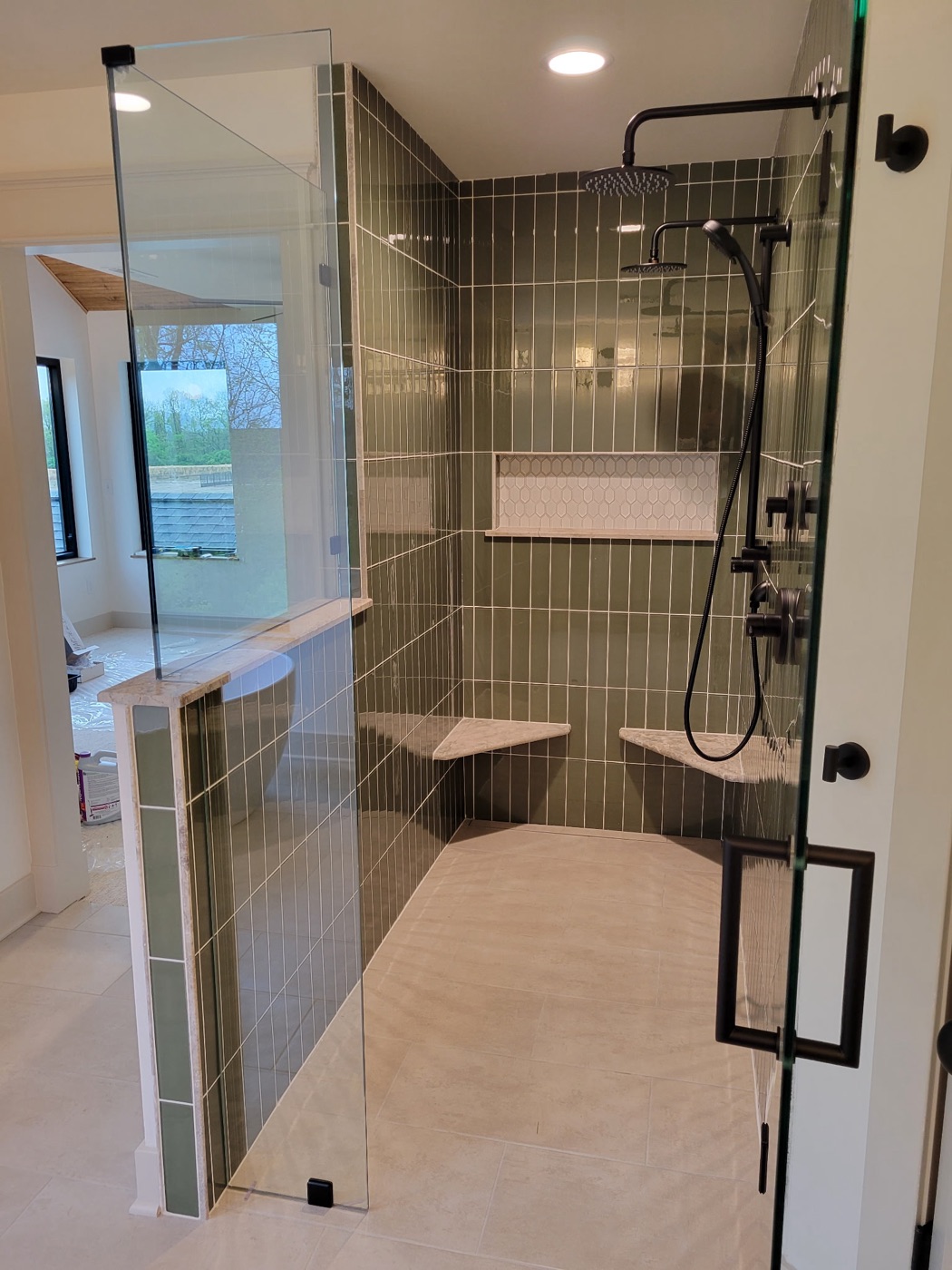 Master bath with green tile shower and freestanding tub