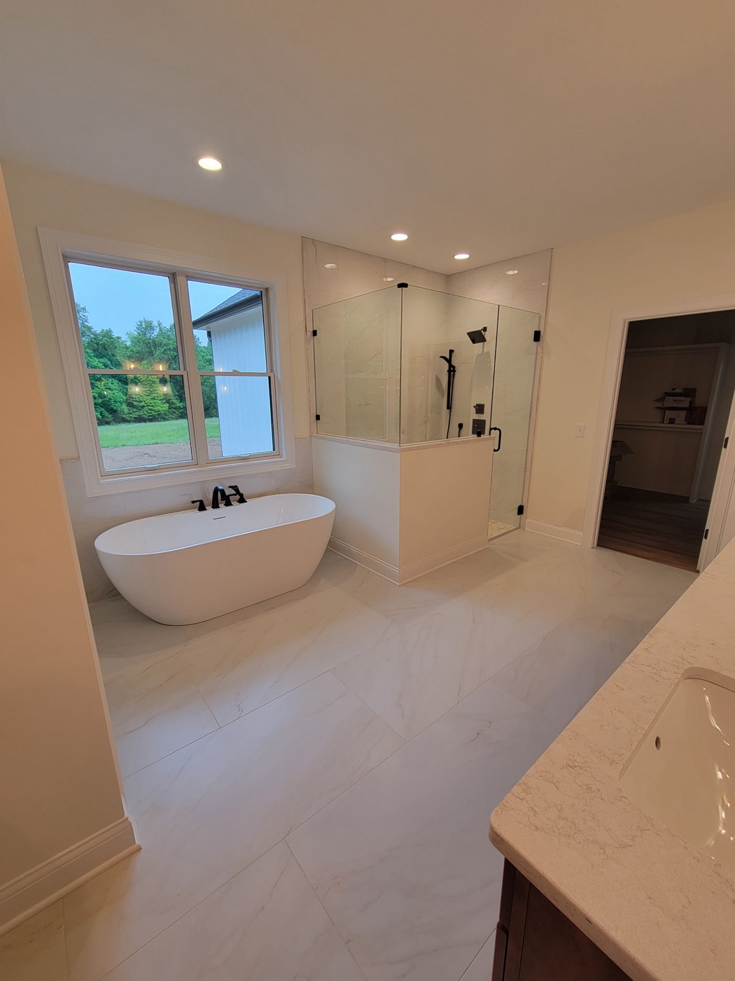 Marble master bath with frameless corner shower