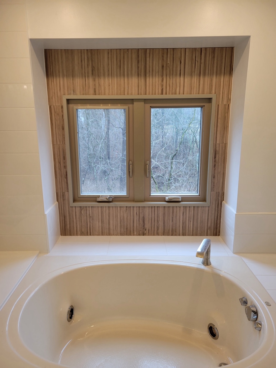 Drop-in jetted tub with a wood-slat window wall