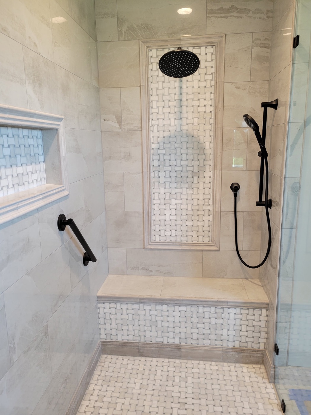 Shower with framed basketweave mosaic accent panel