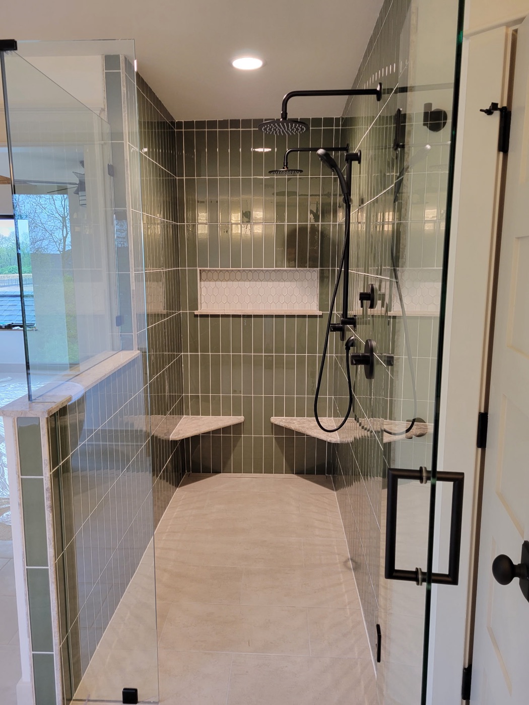 Green tile curbless walk-in shower with dual rainfall heads