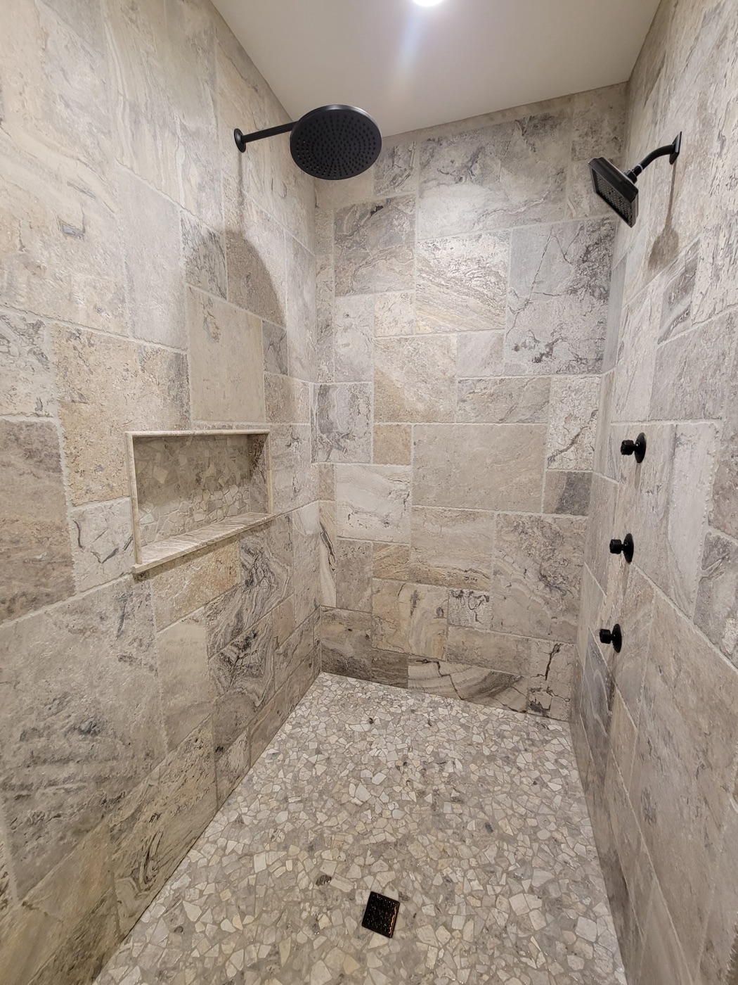 Natural stone shower with pebble floor