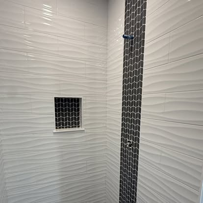 Textured tile shower with mosaic accent